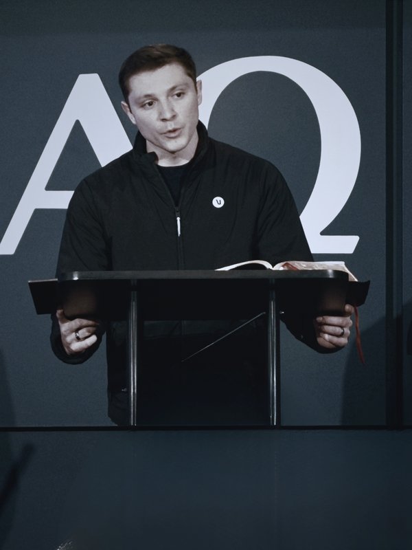 Andrew Ramirez preaching at the pulpit with an open Bible